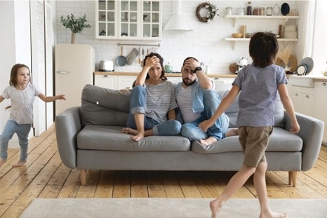 Parents sitting on couch, frustrated with their ADHD prone children