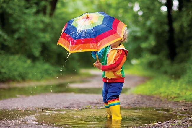 Child outdoors holding an umbrella - metaphor for bedwetting or enuresis